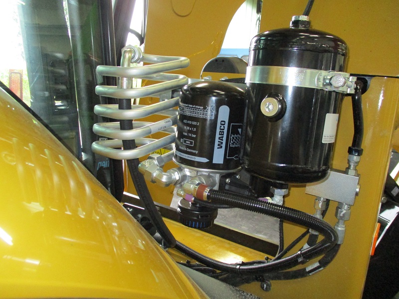 Air dryer assembly on a Caterpillar backhoe loader